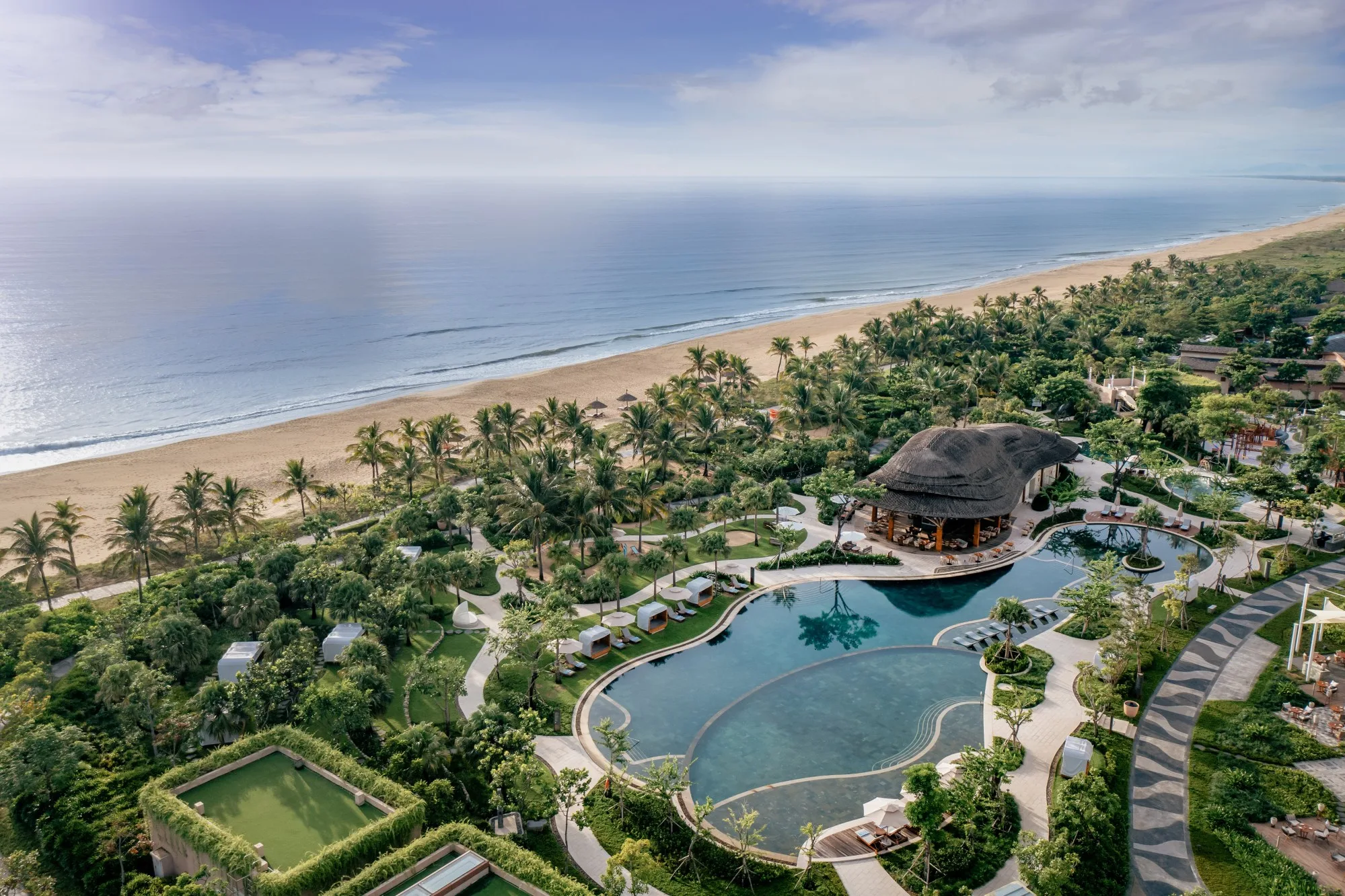 New World Hoiana 海濱的沙灘、椰林與泳池實景。 Photo: New World Hotels & Resorts / Rosewood Hotel Group. Source: https://newworldhotels.com/en/gallery/new-world-hoiana-beach-resort/